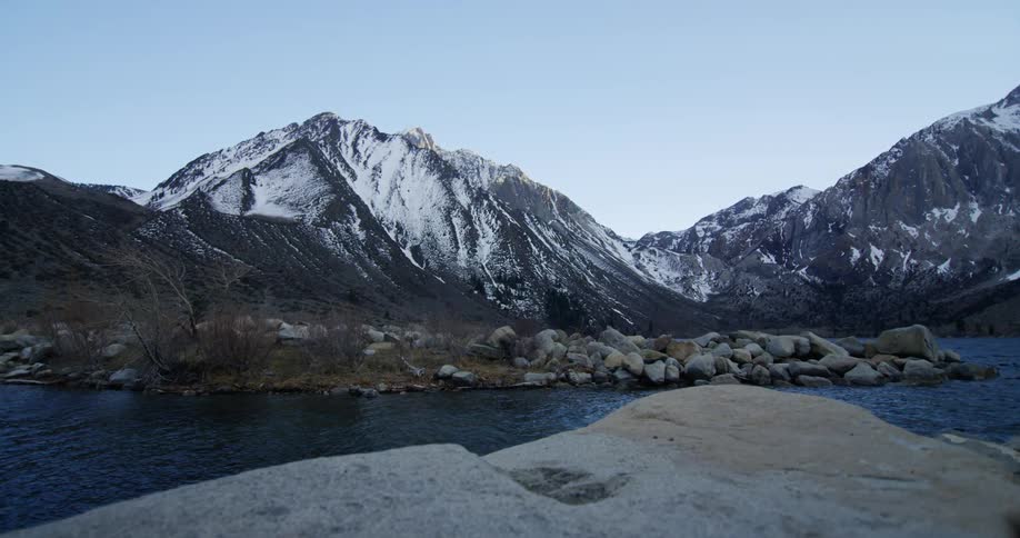 A stream flows through the rocky valley between some mountains