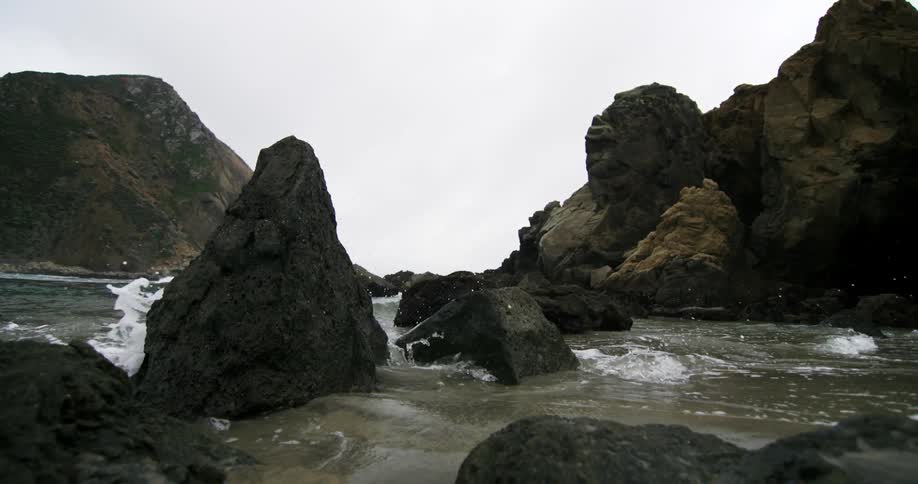Waves crash onto rocks along the shore