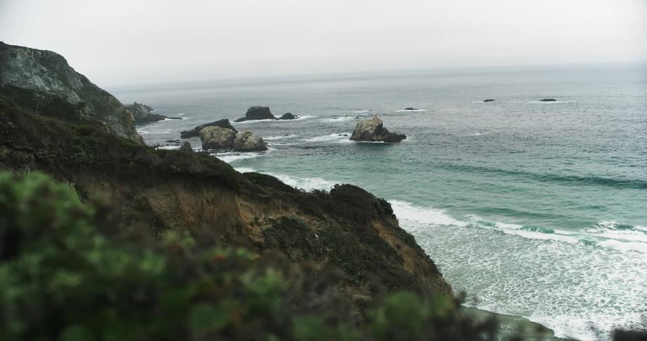 The waves crash against the rocky shore