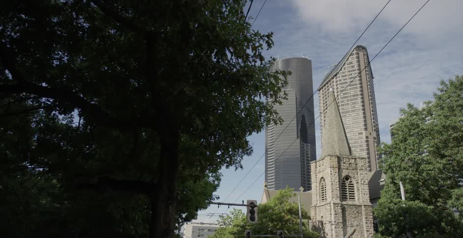 Skyscrapers tower above a church on a sunny day