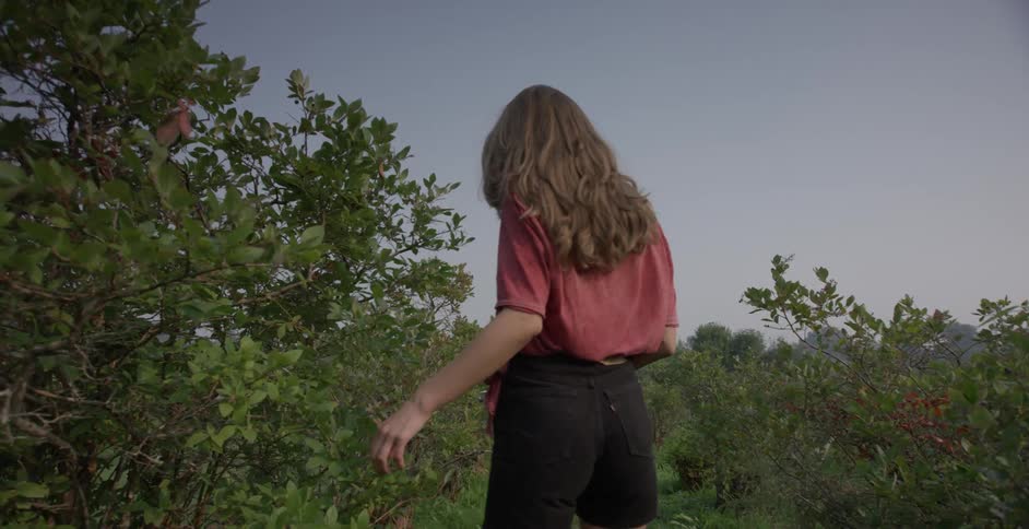 A woman is walking through a forest area