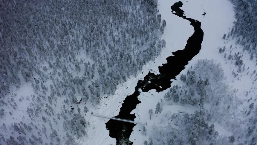A snow covered and frozen river is partially melted
