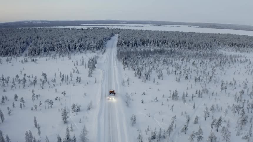 A car is driving in a winter landscape