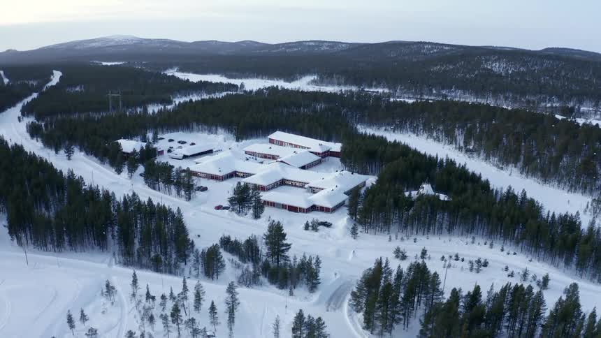 Buildings surrounded by pine forest and snow in winter