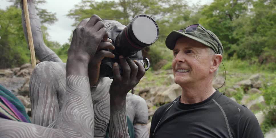 A man uses a camera takes a photograph
