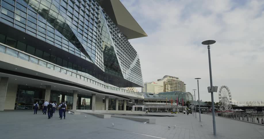 A group of police officers walking towards a large building in a city