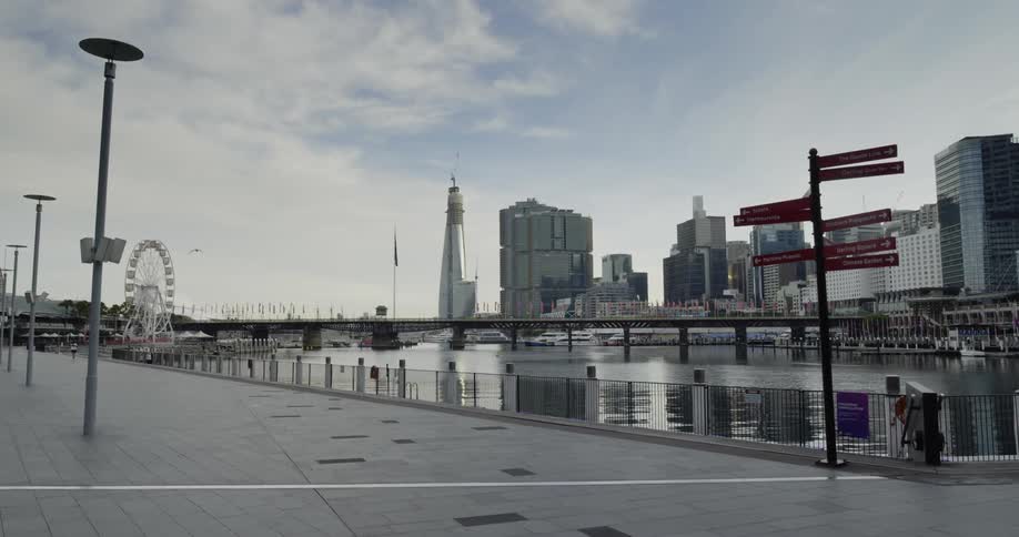 A boardwalk on the river with the city skyline in the background