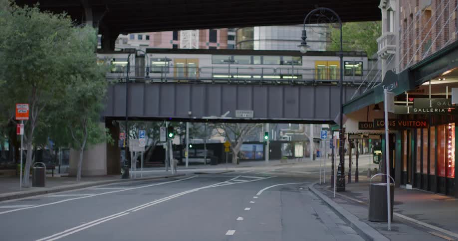 A train travels along a bridge over a city street in a metropolis