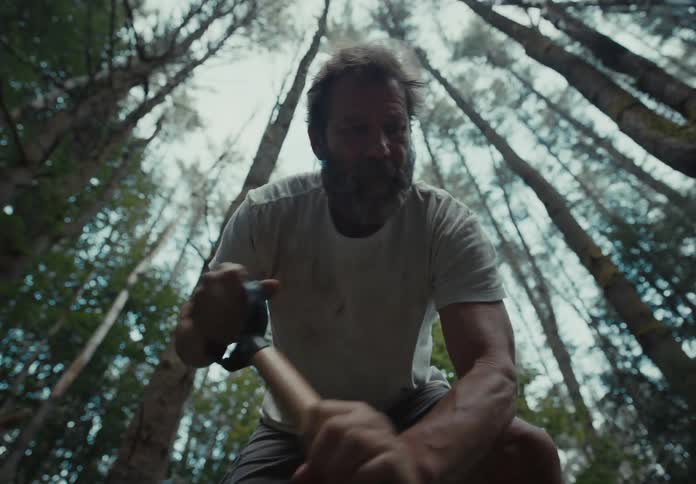 Man frantically digging a hole in the middle of the forest
