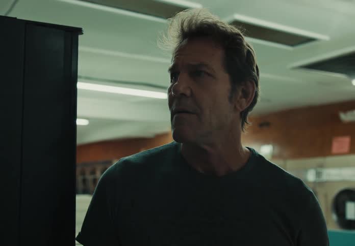 Man alone in laundromat looks concerned
