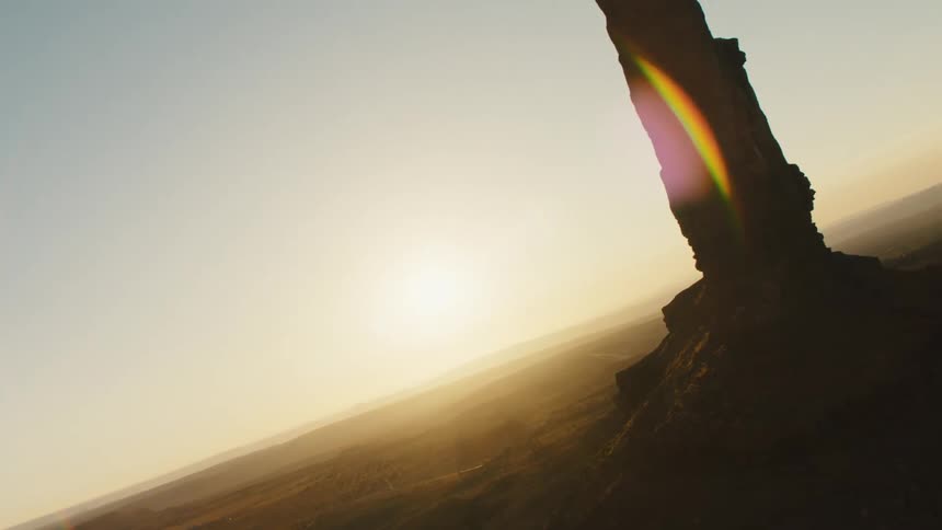 Aerial view of the sun shining over rocks in the badlands