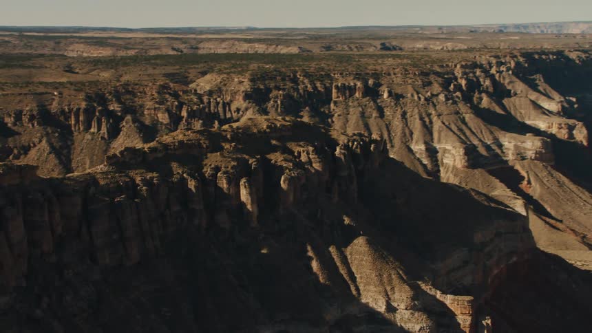 A desert with canyons and cliffs with the sky in the background