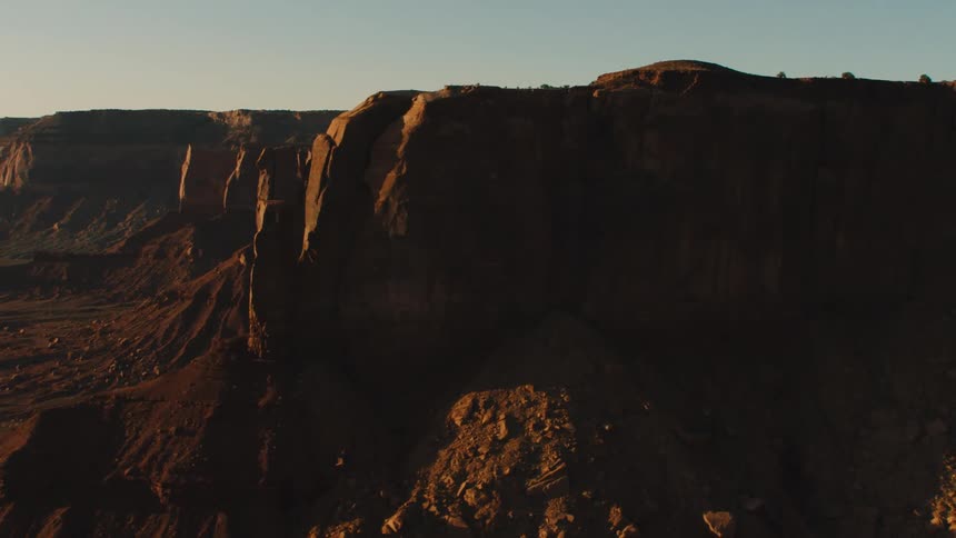 A valley lies below tall rocky cliffs