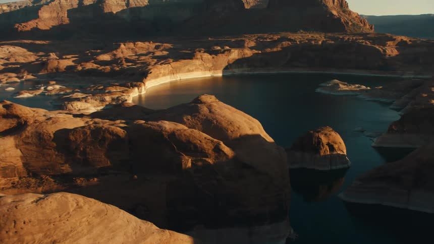 A lake in the desert with cliffs and the sky in the background