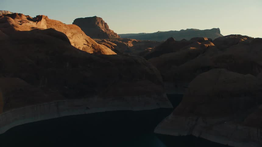 River winds through canyon in shadowed badlands