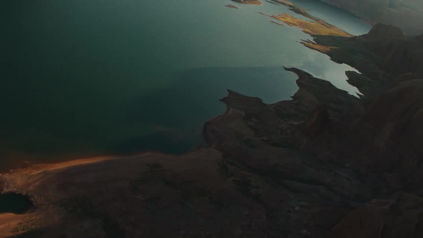 A deep blue lake lies between some rocky cliffs