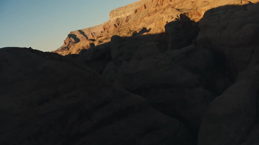 A shadowy canyon cuts through a rocky area