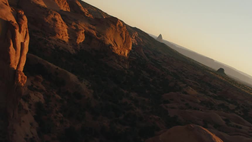 The sun illuminates the faces of tall rock formations