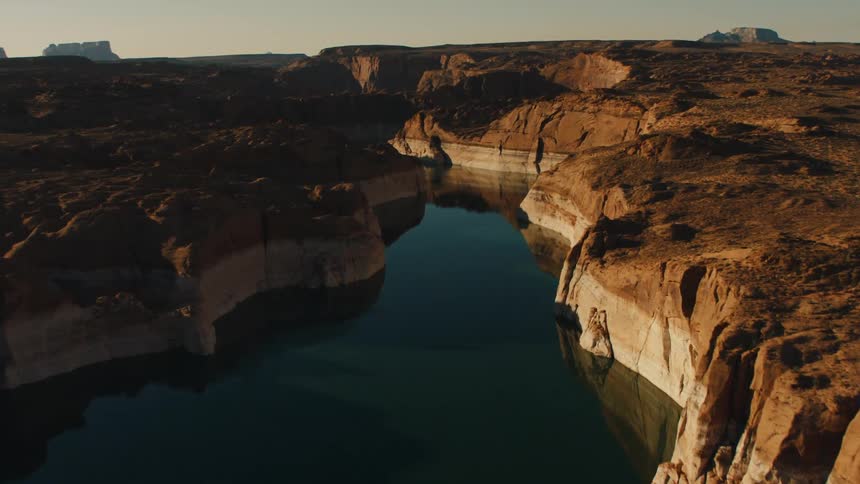 The water is calm between the mountains