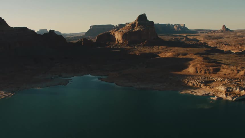 A deep blue lake lies in the middle of a flat rocky area