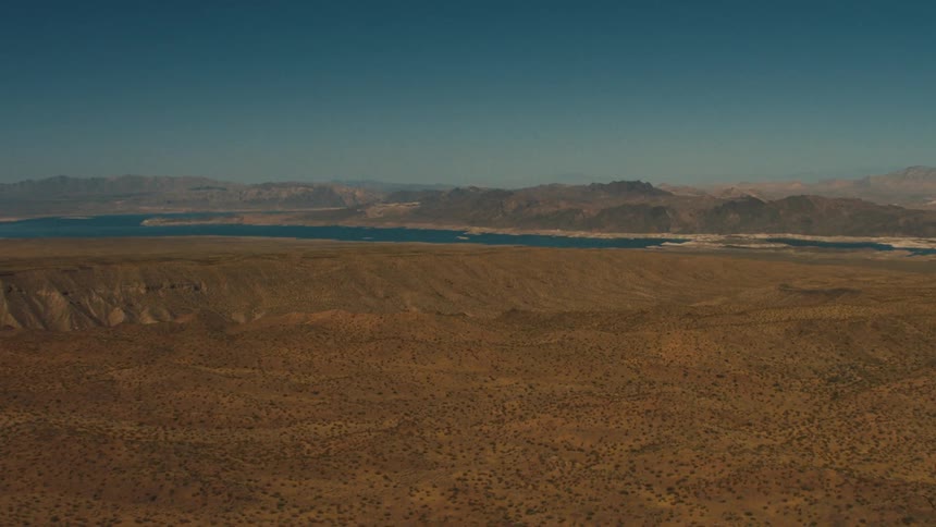 A deep blue river winds through a canyon