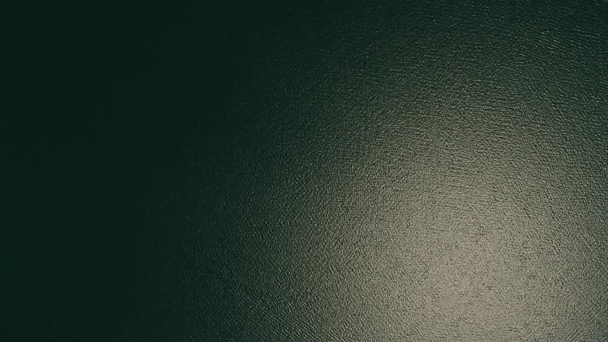 An ocean with sunlight reflecting off the water