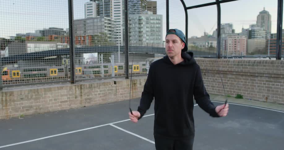 A man is jumping rope on a sports court