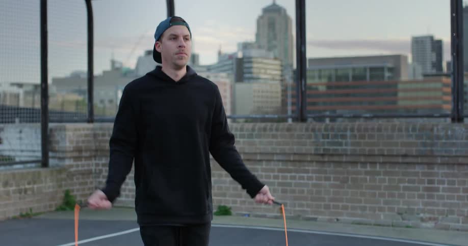 A man jumping rope on the rooftop of a building in a metropolis during the daytime