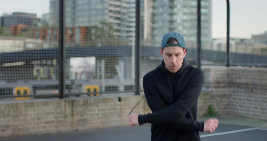 A man is jumping rope in an urban area