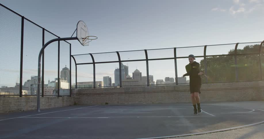 A young man jumps rope on a roof top building