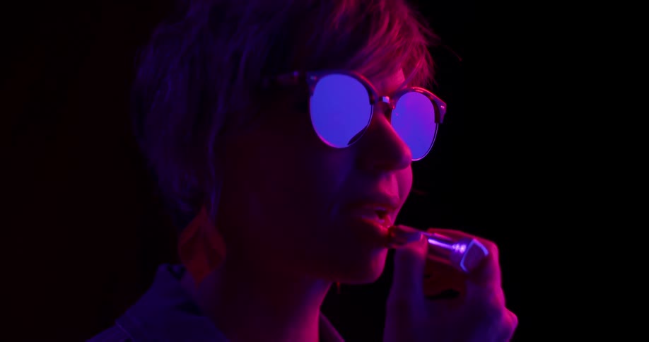 A woman putting on lipstick