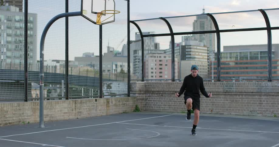 A man jumps rope on a rooftop building