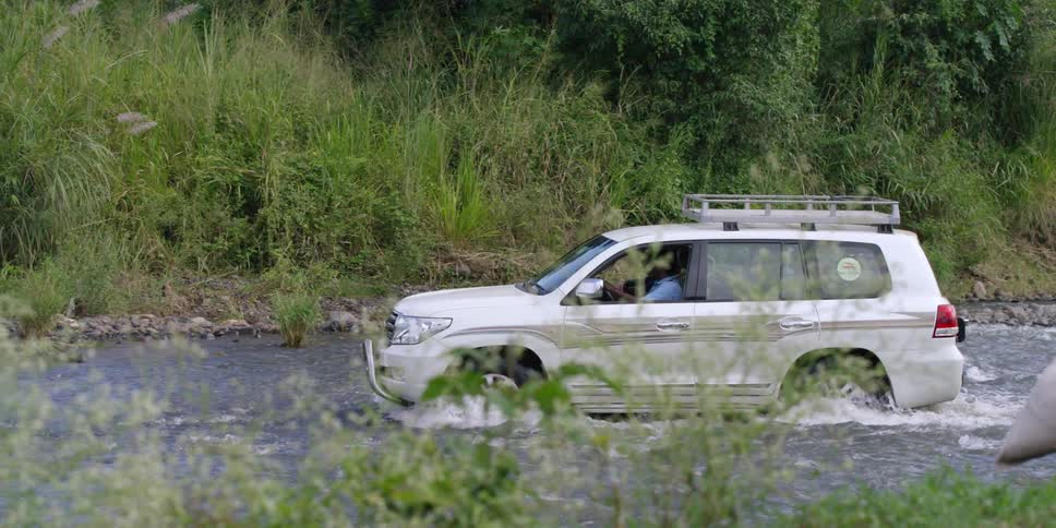 A vehicle is driving through a stream