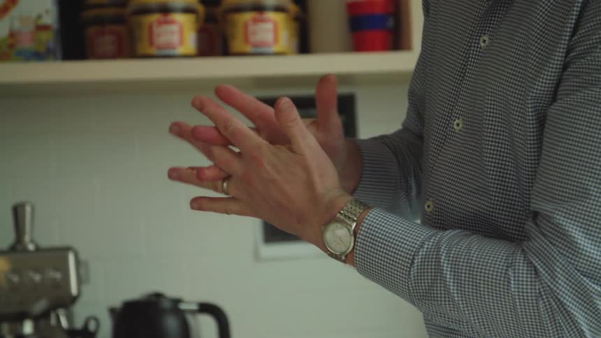 A man is wiping his hands in the kitchen