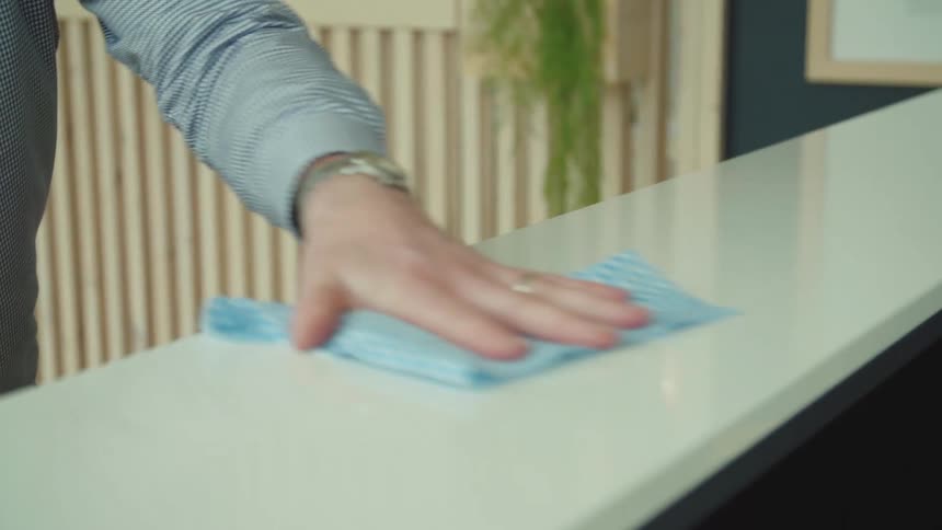 A man wipes his counter with a rag