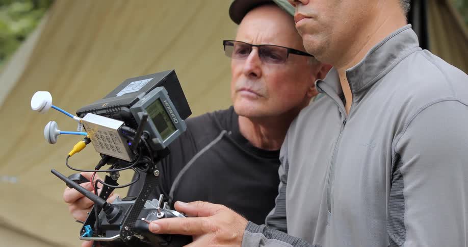 Two men look at a display on a machine