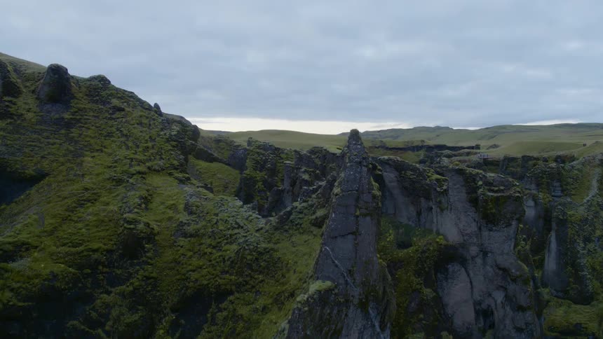 A canyon with a river with the sky and clouds in the background
