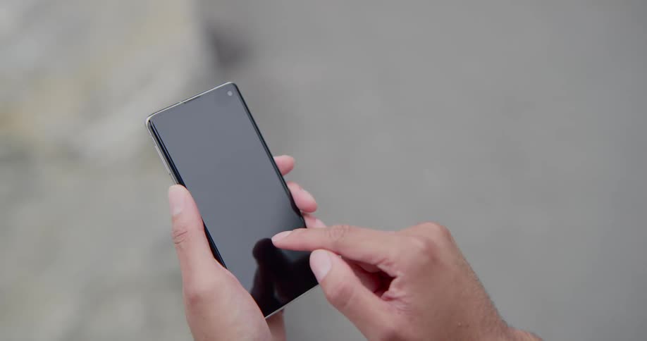 A persons hands holding and touching a smartphone