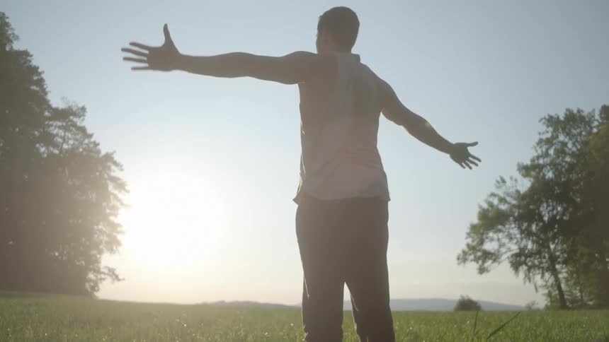 A man rises up stretching his arms