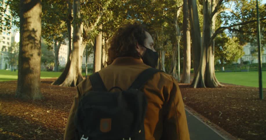 A man is walking outdoors on a sidewalk