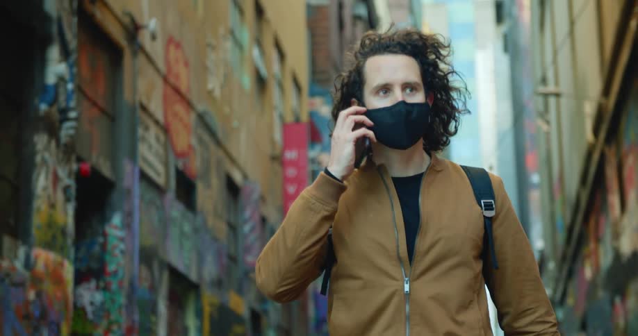 A man is walking through a downtown city