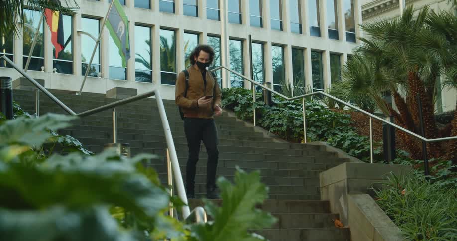A man is walking down a flight of stairs in a city