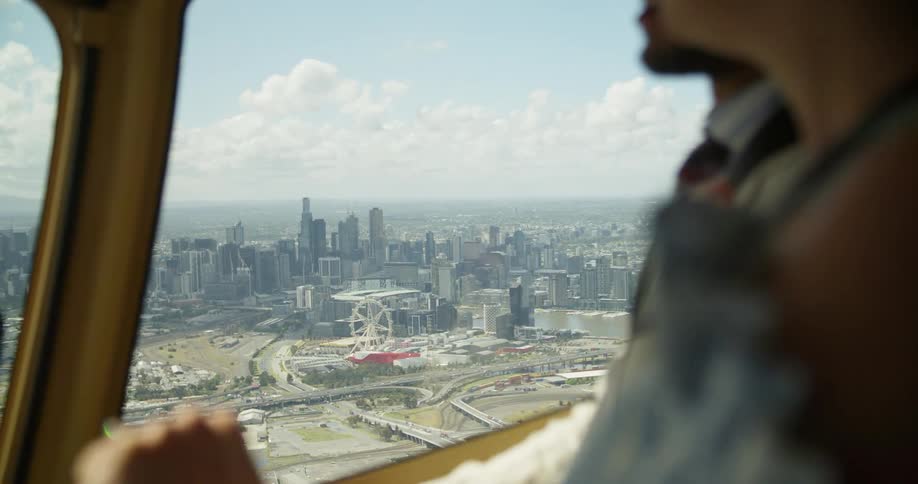 Two men flying an airplane over a city
