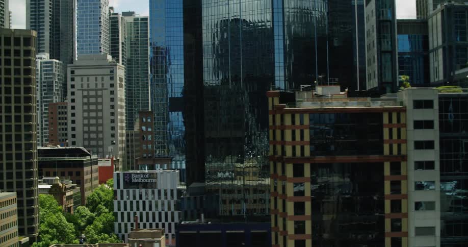 Vegetation dots streets and tops of mid rise buildings amid skyscrapers of downtown