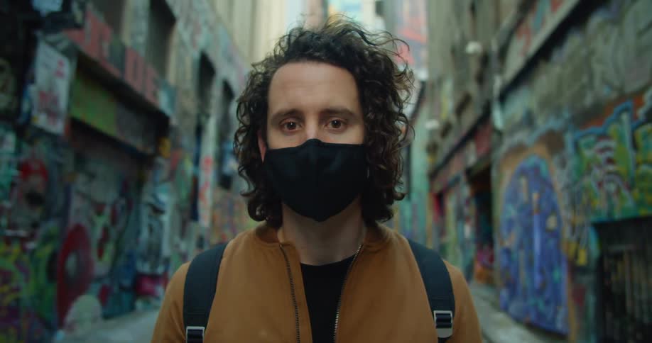A man is walking while wearing a mask