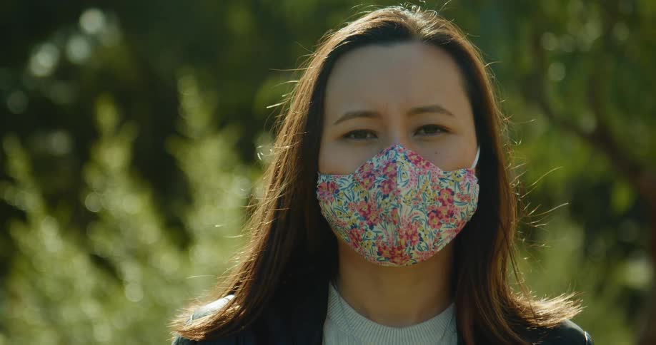 A woman is wearing a facemask in the forest