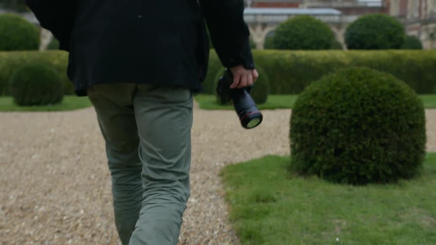 A man is walking and holding a camera