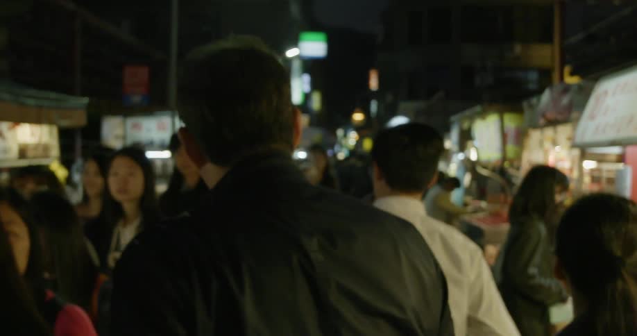 People walking on a busy street at night time