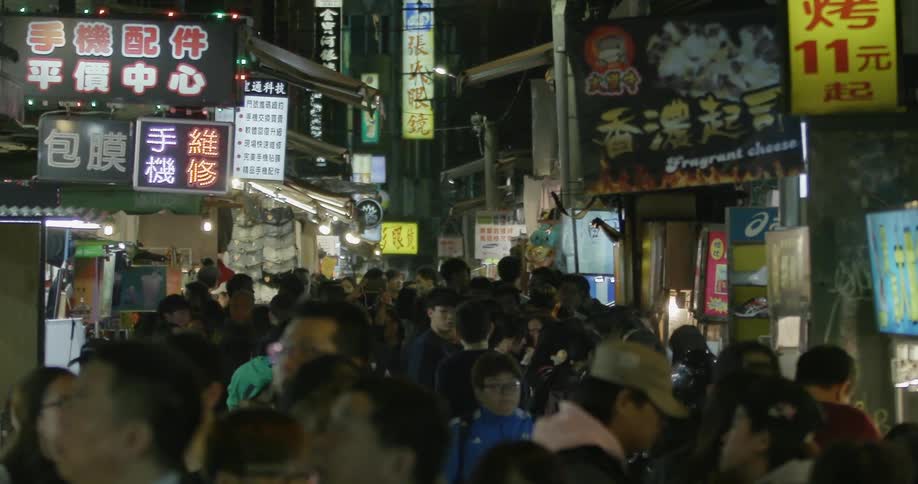 A large crowd of people on street with shops