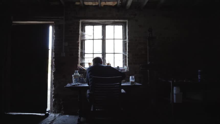 A man sitting at a desk writing something